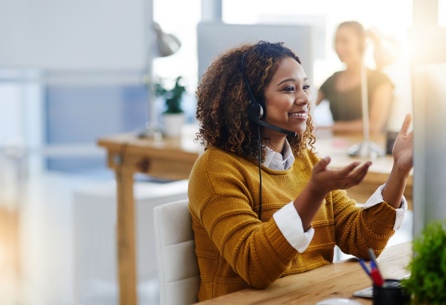 Financial Success in Consulting Services a young women consulting this topic with a client via headphones.