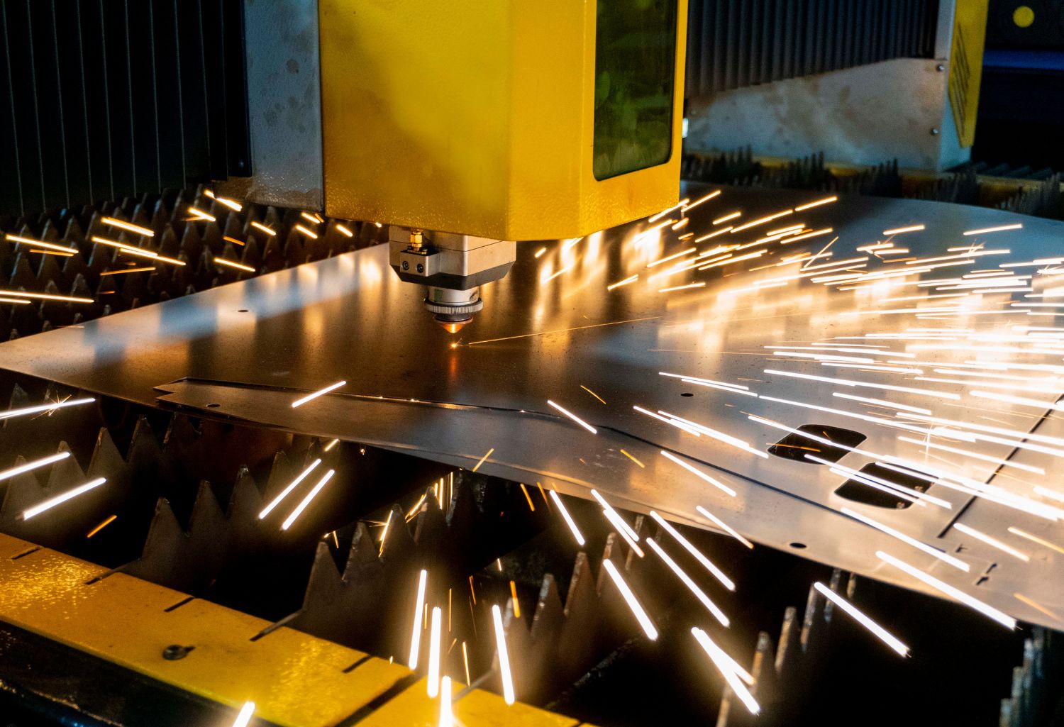 Laser cutting of metal sheet with sparks stock photo. Industrial Equipment Manufacturing